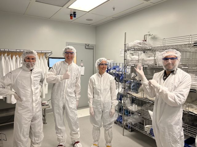 Armel, Cecile, Liam, and Peter getting dressed for the clean room
